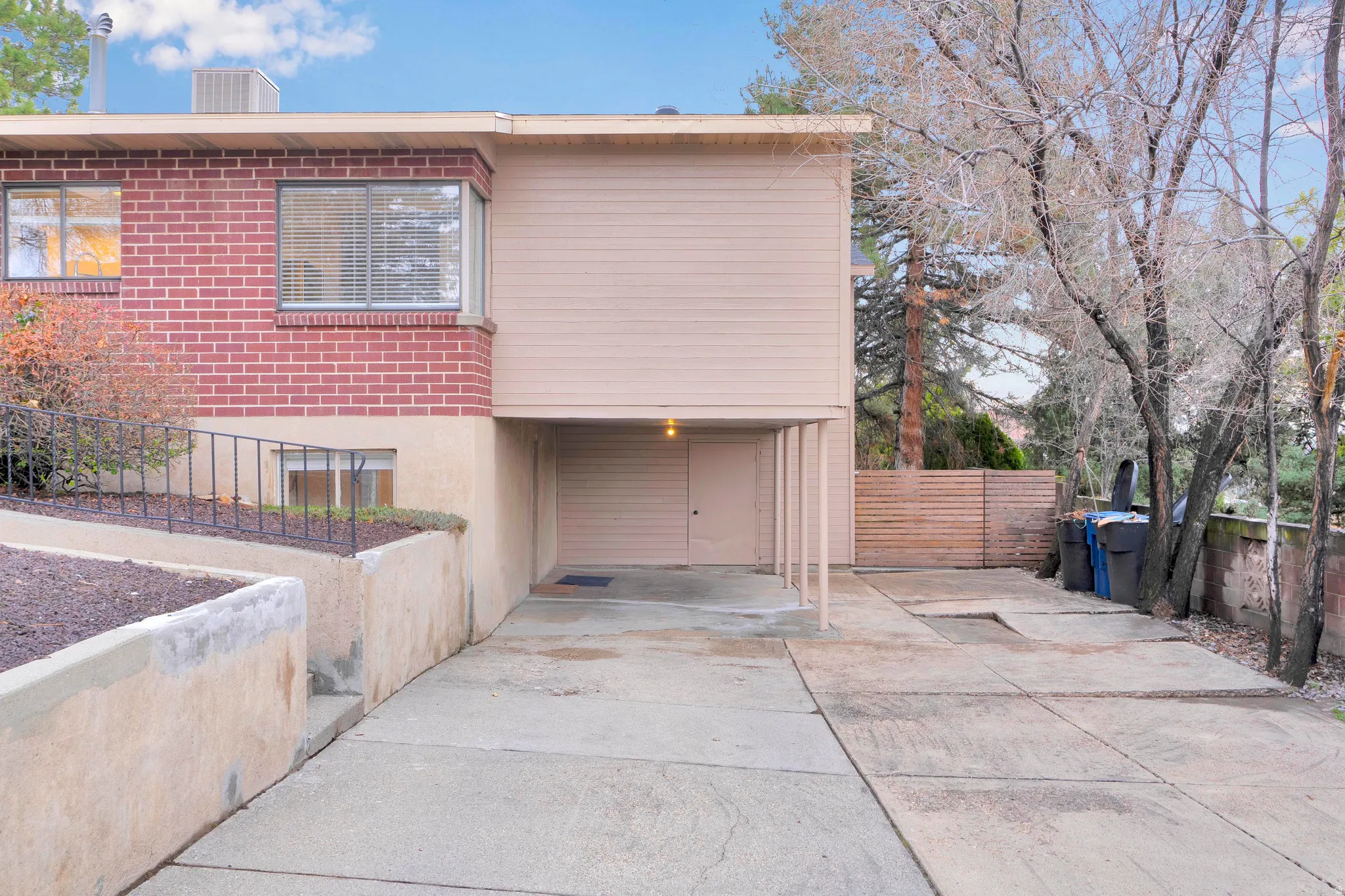 View of front of home with concrete driveway, brick siding, and a carport