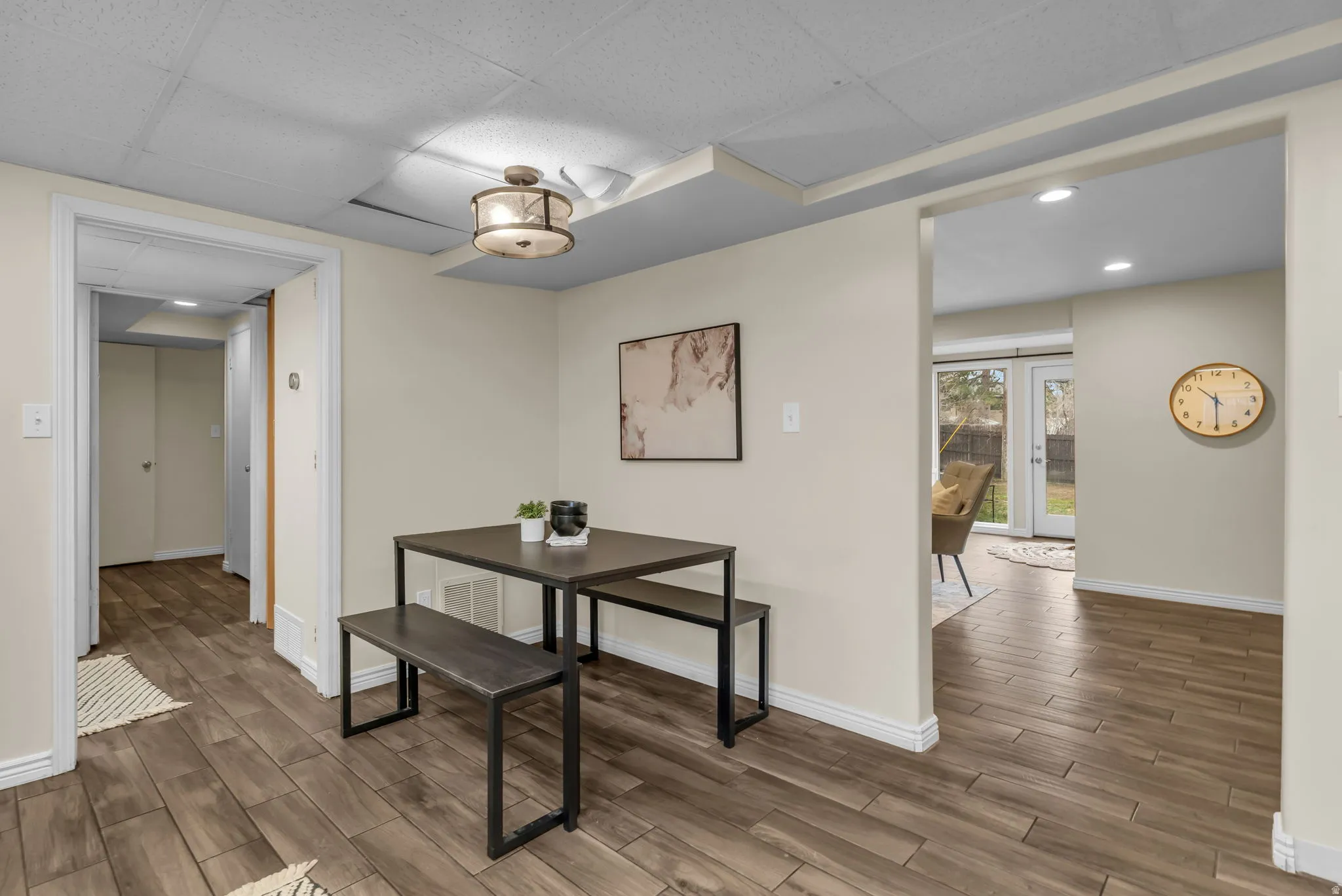 Dining space with wood finish floors, recessed lighting, and a paneled ceiling