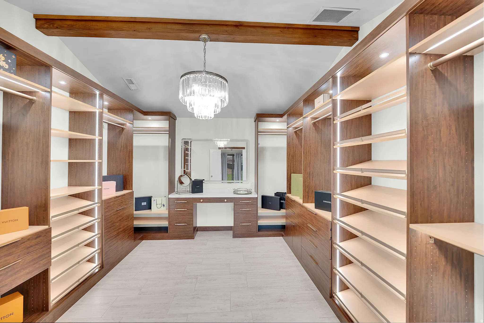 Walk in closet with hanging lights and lofted ceiling with beams
