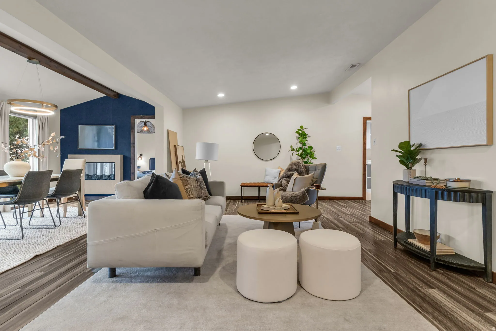 Living area with lofted ceiling with beams, wood finished floors, and recessed lighting
