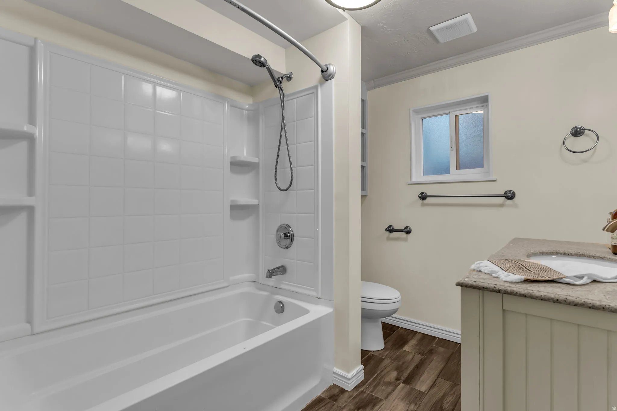 Full bath featuring vanity, dark wood-style floors, bathing tub / shower combination, and crown molding