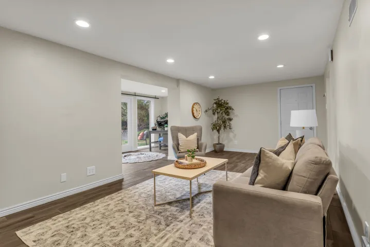 Living area with recessed lighting and dark wood-style floors