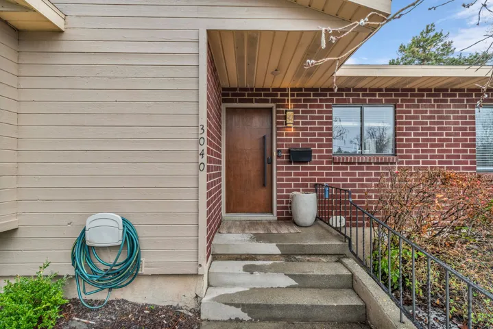 View of exterior entry featuring brick siding