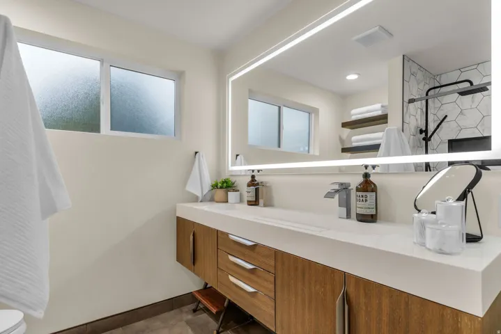 Full bathroom with vanity, dark tile patterned flooring, and a shower