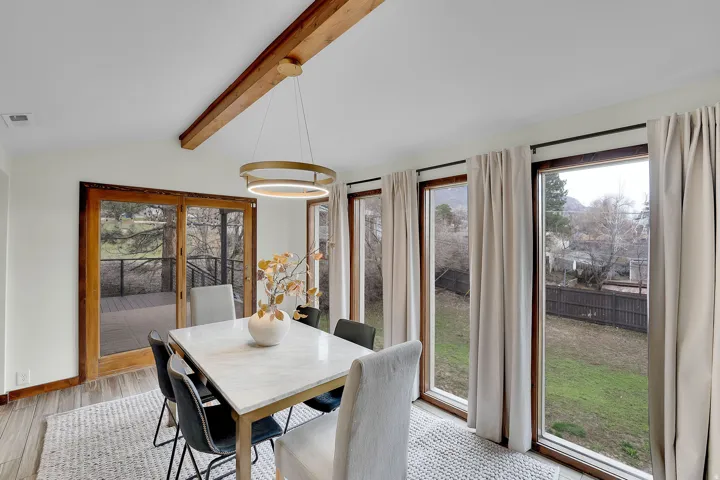 Dining area with lofted ceiling with beams, plenty of natural light, and light wood-style floors