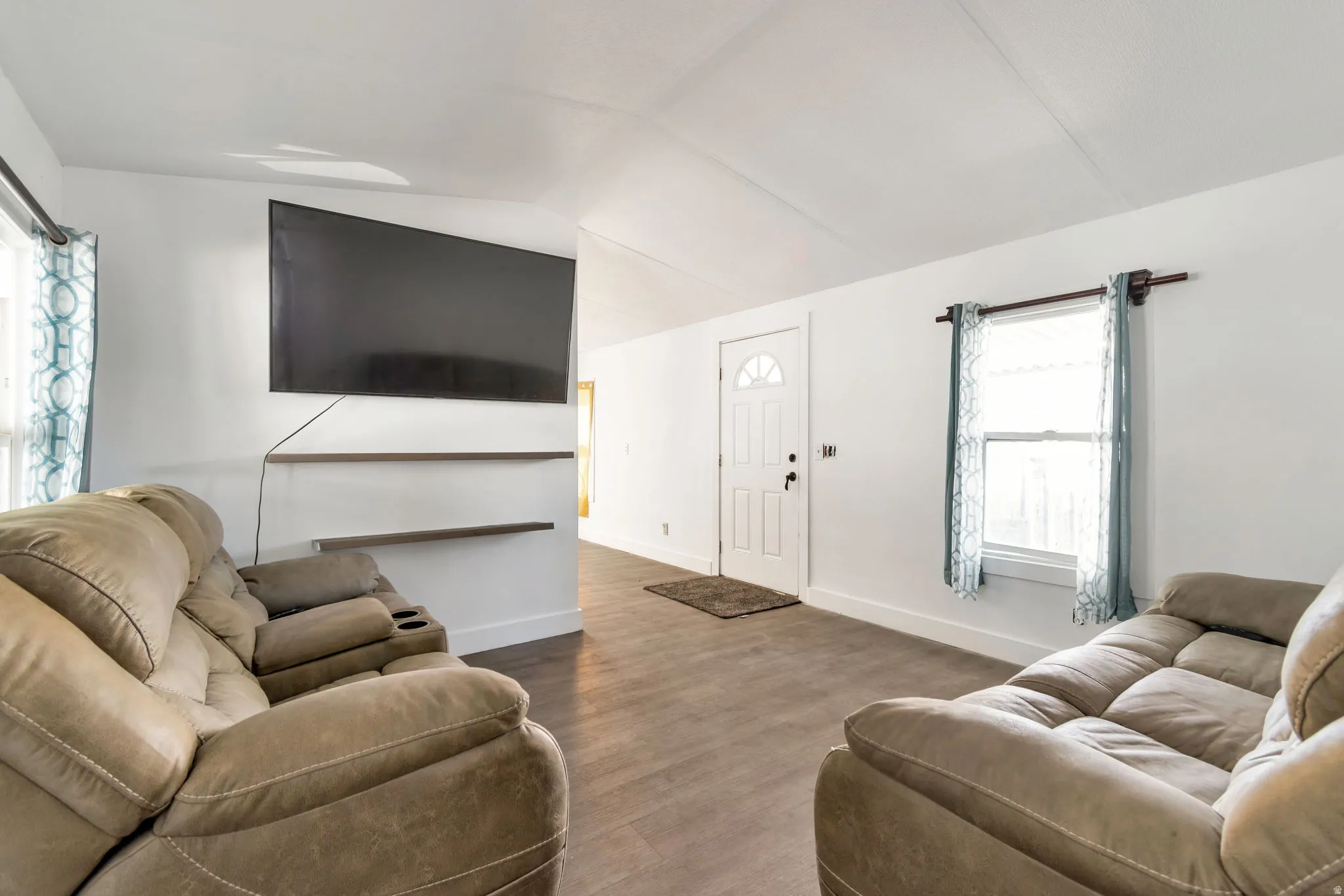 Living room with dark wood-type flooring and lofted ceiling