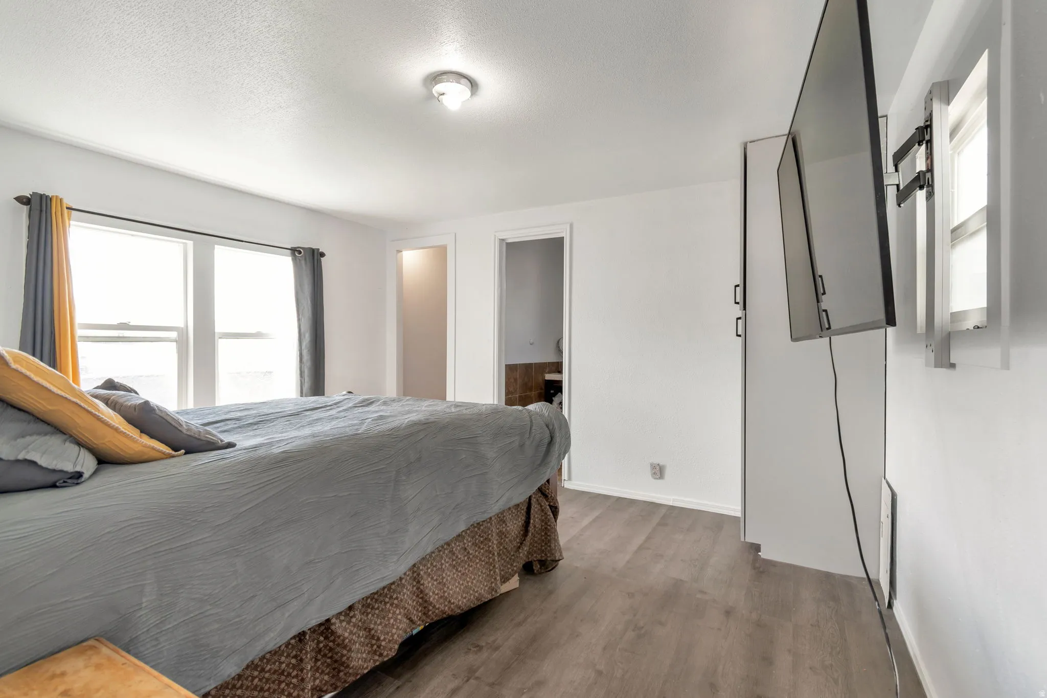 Bedroom with wood finished floors and a textured ceiling