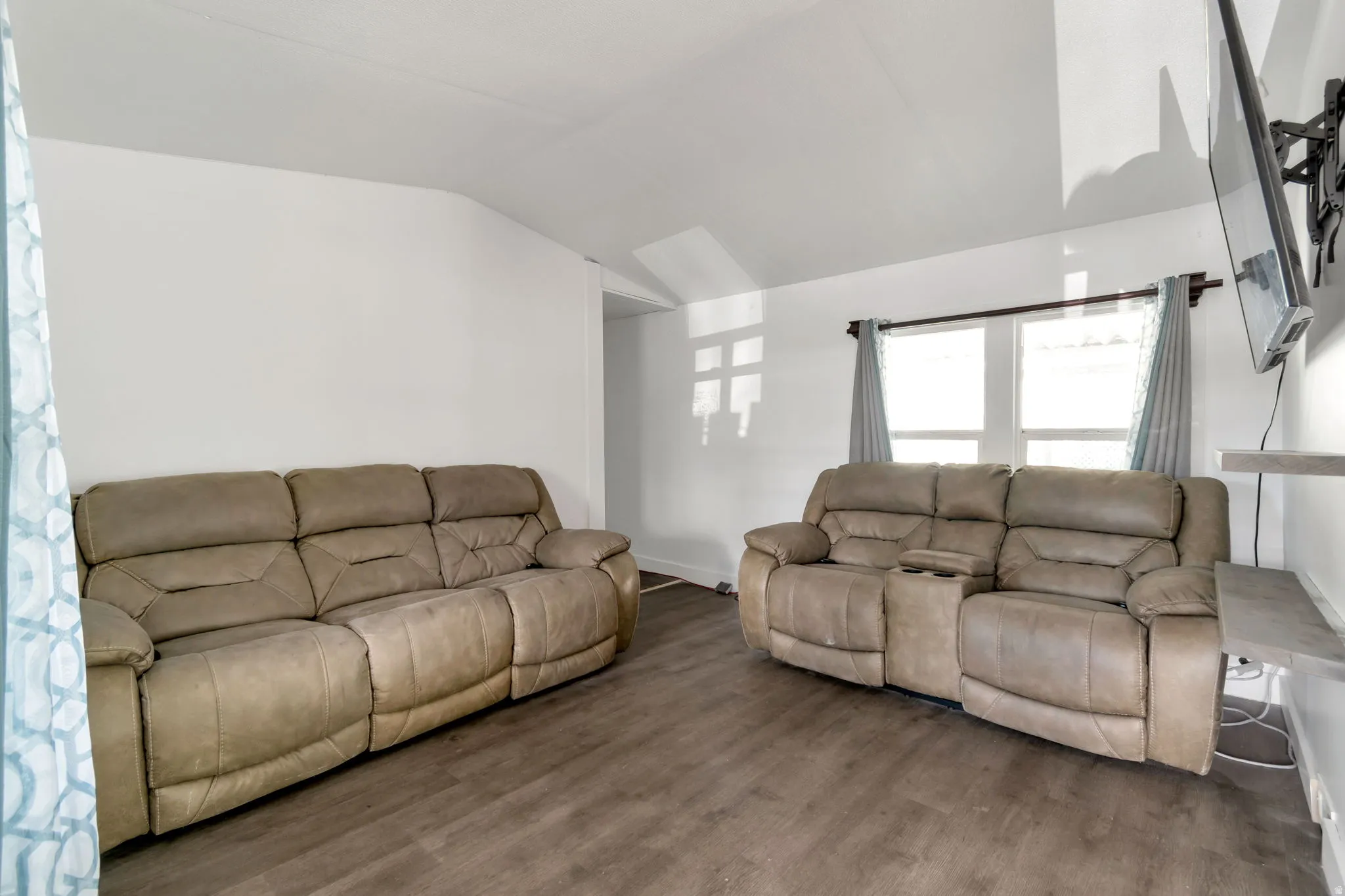 Living area featuring wood finished floors and lofted ceiling