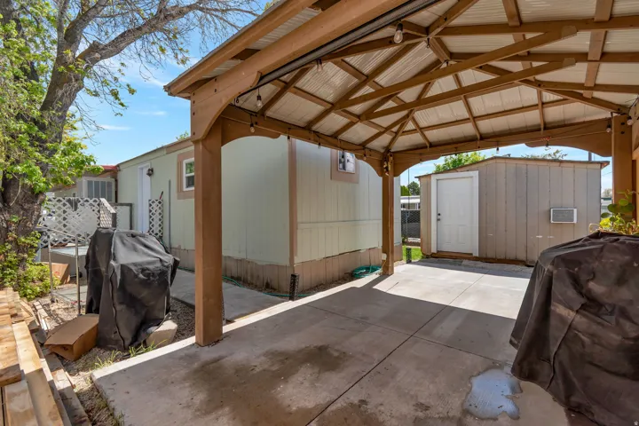 View of parking featuring a storage unit and a wall unit AC