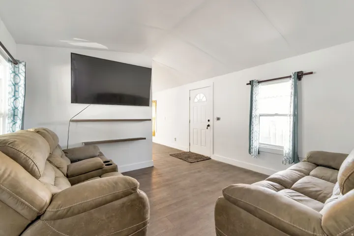 Living room with dark wood-type flooring and lofted ceiling