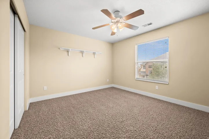 Unfurnished bedroom featuring a closet, carpet floors, and a ceiling fan
