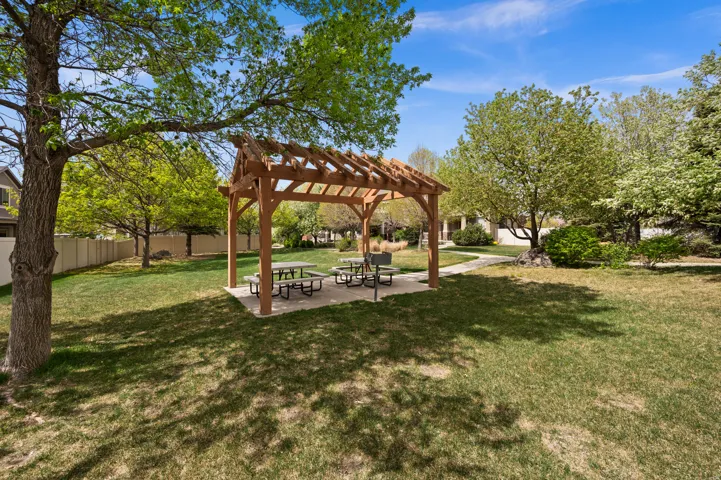 View of green lawn featuring a pergola and a patio