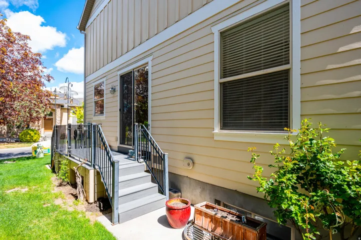 View of exterior entry featuring board and batten siding and a yard