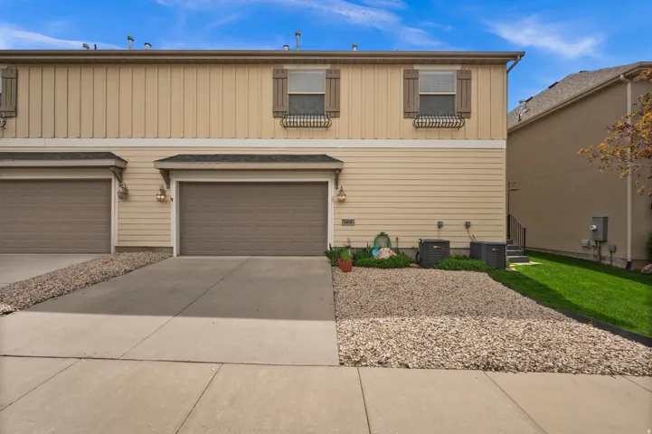 View of front facade featuring concrete driveway, an attached garage, and board and batten siding