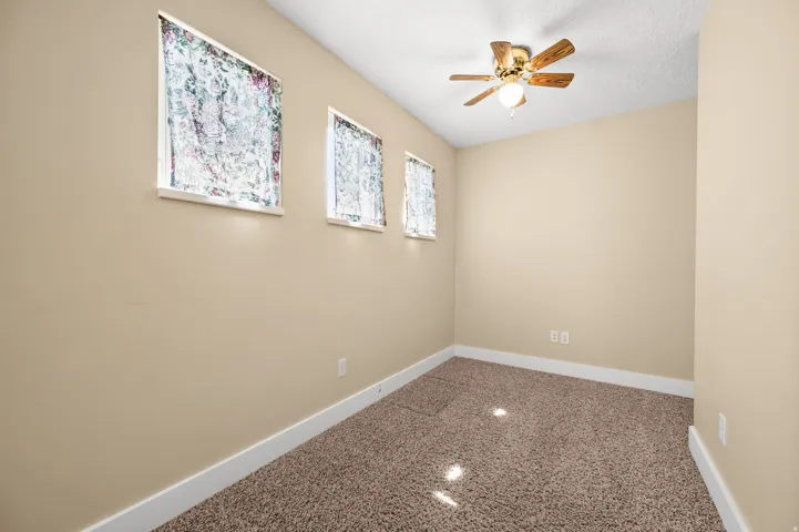 Empty room with a ceiling fan and a textured ceiling