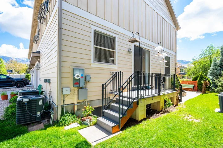 View of exterior entry featuring board and batten siding, a yard, and a mountain view