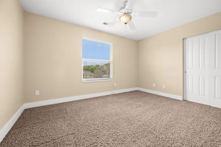 Unfurnished bedroom with carpet floors, a closet, and ceiling fan