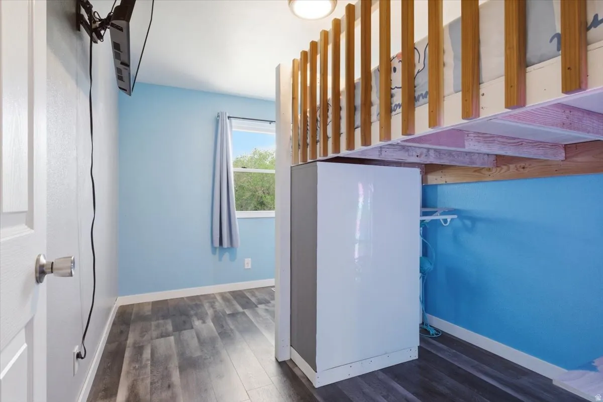 Stairway with wood finished floors and baseboards