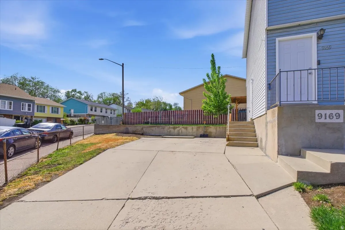 View of concrete driveway with street lights and a residential view