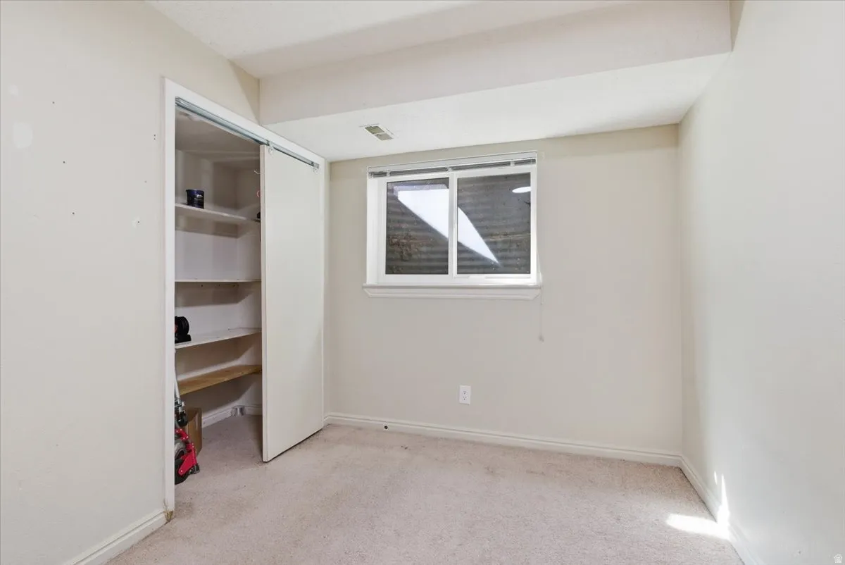 Unfurnished bedroom with light colored carpet and a closet