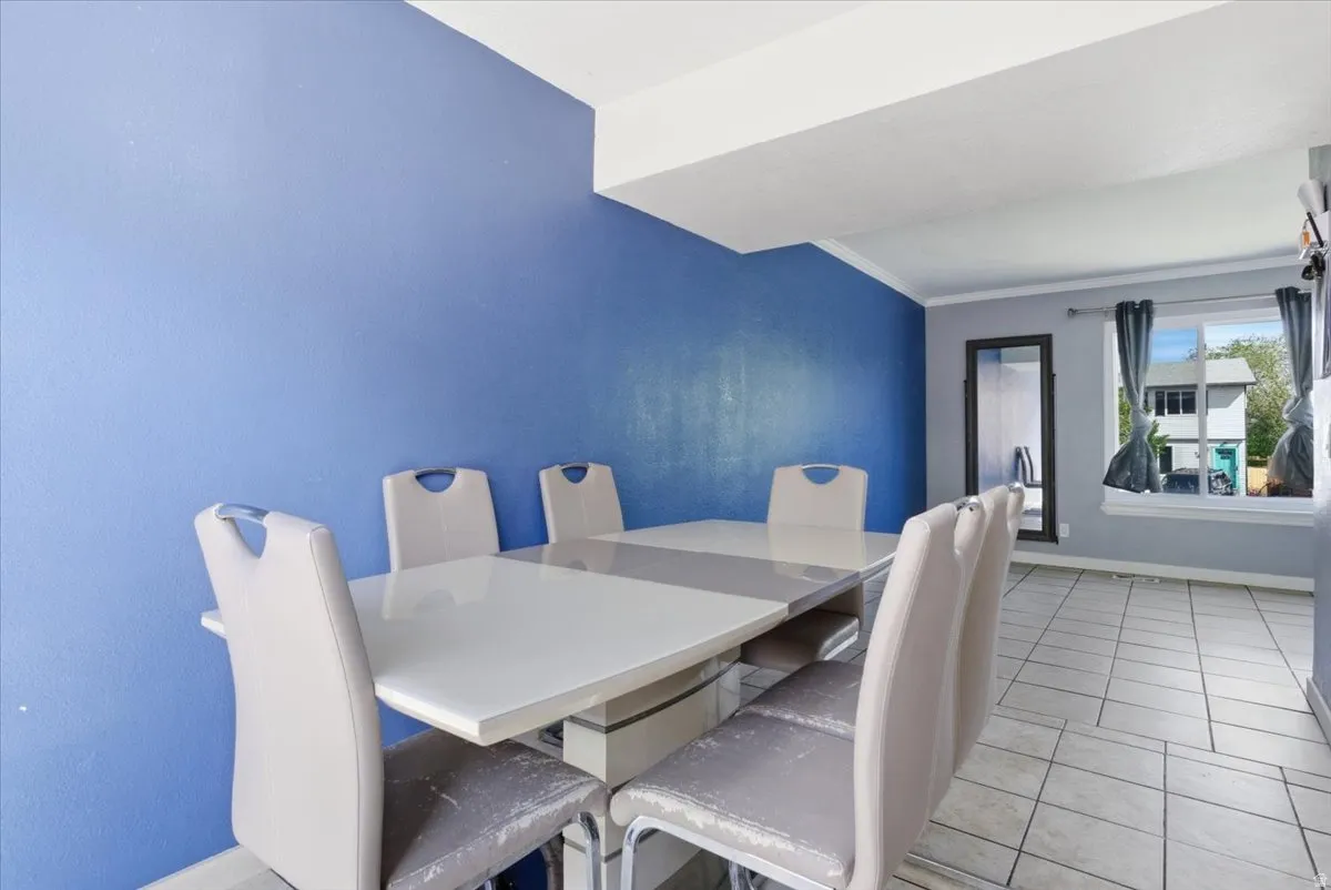 Dining area featuring light tile patterned flooring and ornamental molding