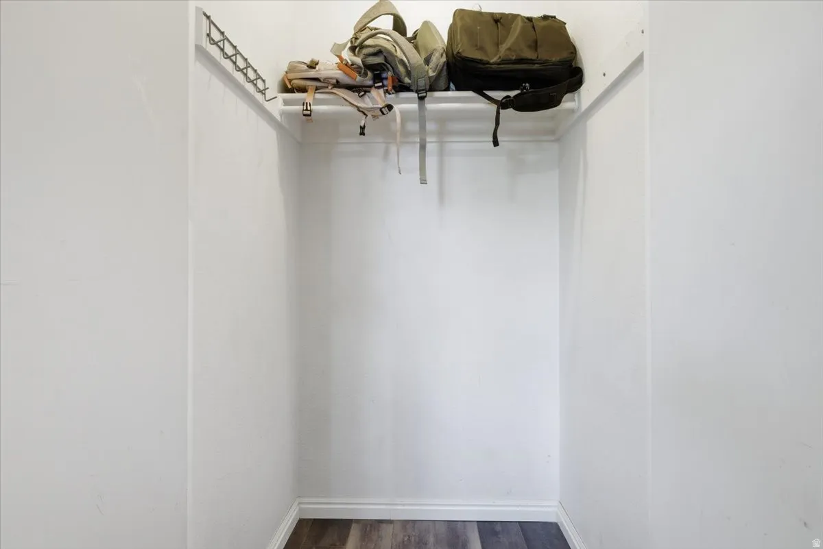 Walk in closet featuring dark wood-style floors