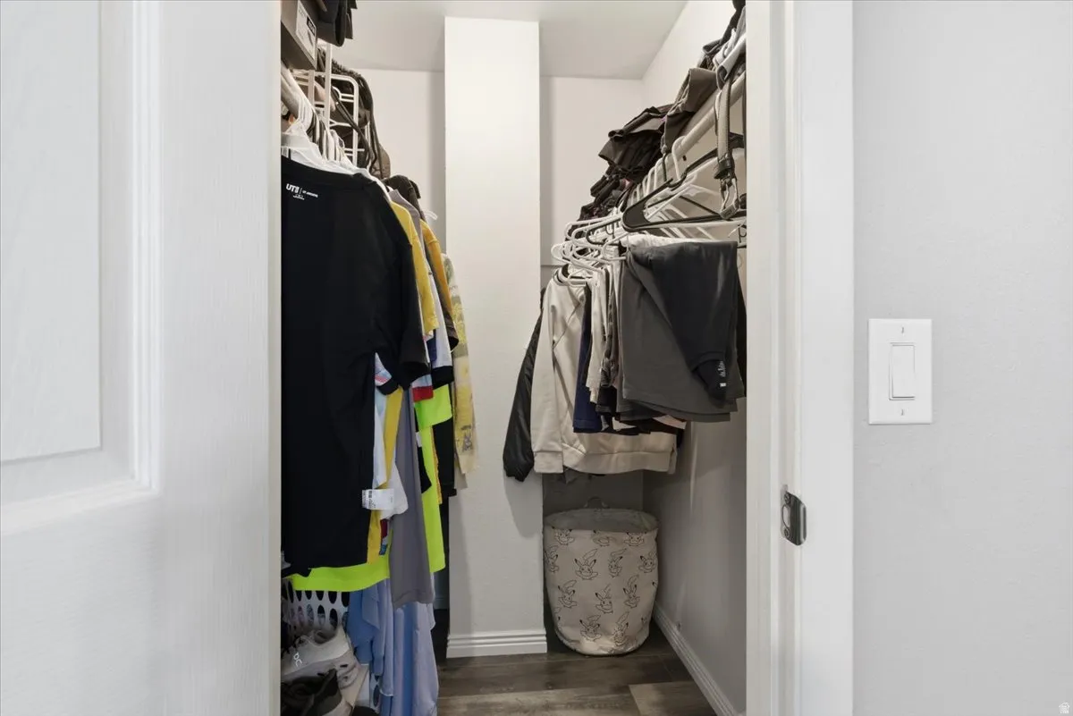 Walk in closet featuring dark wood finished floors