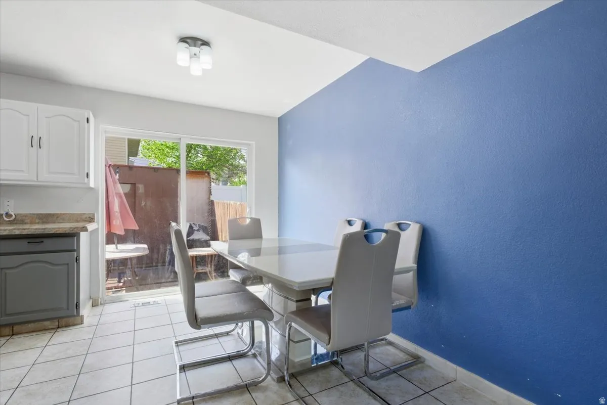 Dining room with light tile patterned flooring and a textured wall