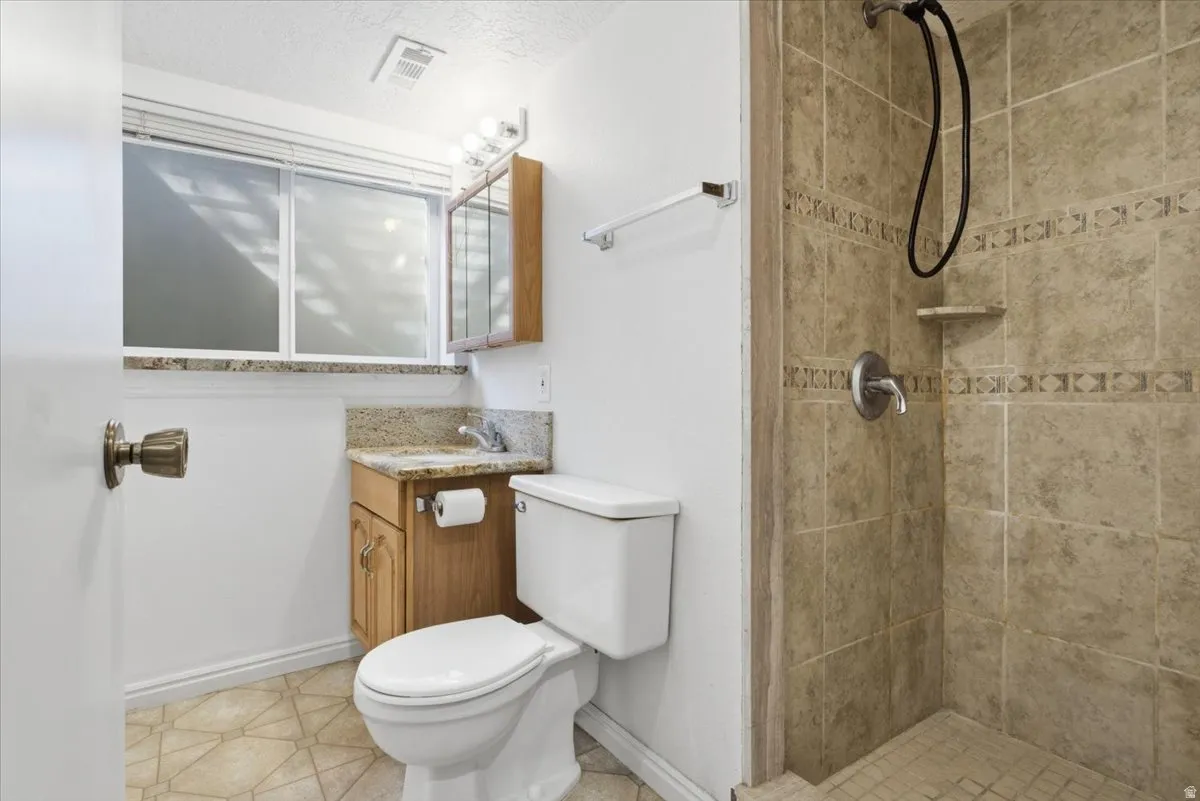 Bathroom with vanity, a stall shower, and a textured ceiling