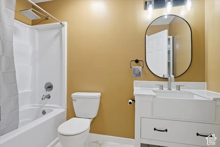 Bathroom featuring vanity, shower / bath combo, and marble look tile flooring