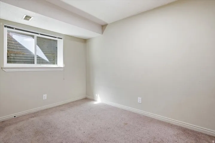Carpeted empty room featuring baseboards
