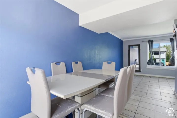 Dining area featuring light tile patterned flooring and ornamental molding