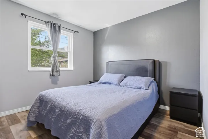 Bedroom with wood finished floors and baseboards