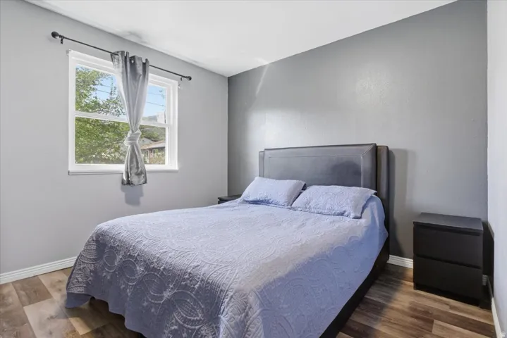 Bedroom with wood finished floors and baseboards