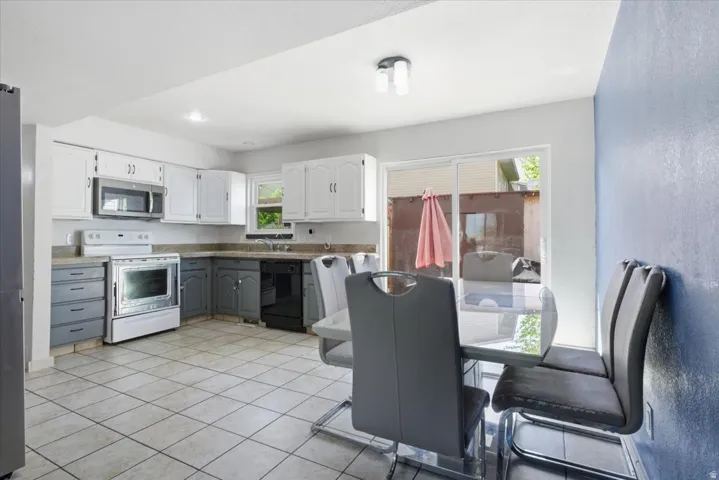 Kitchen with two tone color scheme, stainless steel appliances, and light tile patterned floors