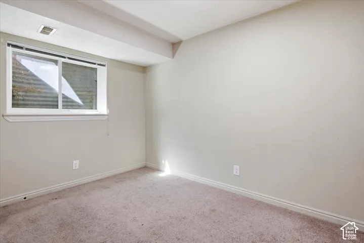 Carpeted empty room featuring baseboards