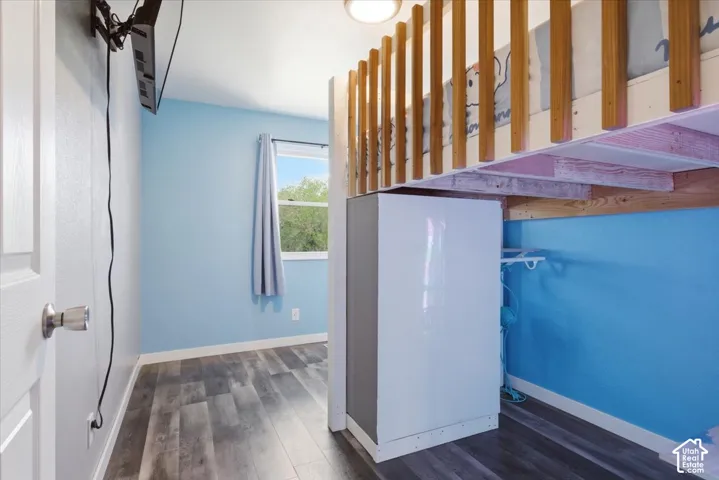 Stairway with wood finished floors and baseboards