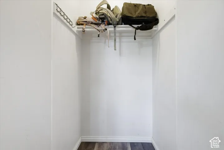 Walk in closet featuring dark wood-style floors