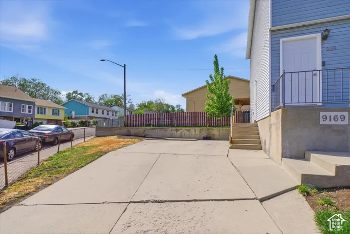 View of concrete driveway with street lights and a residential view
