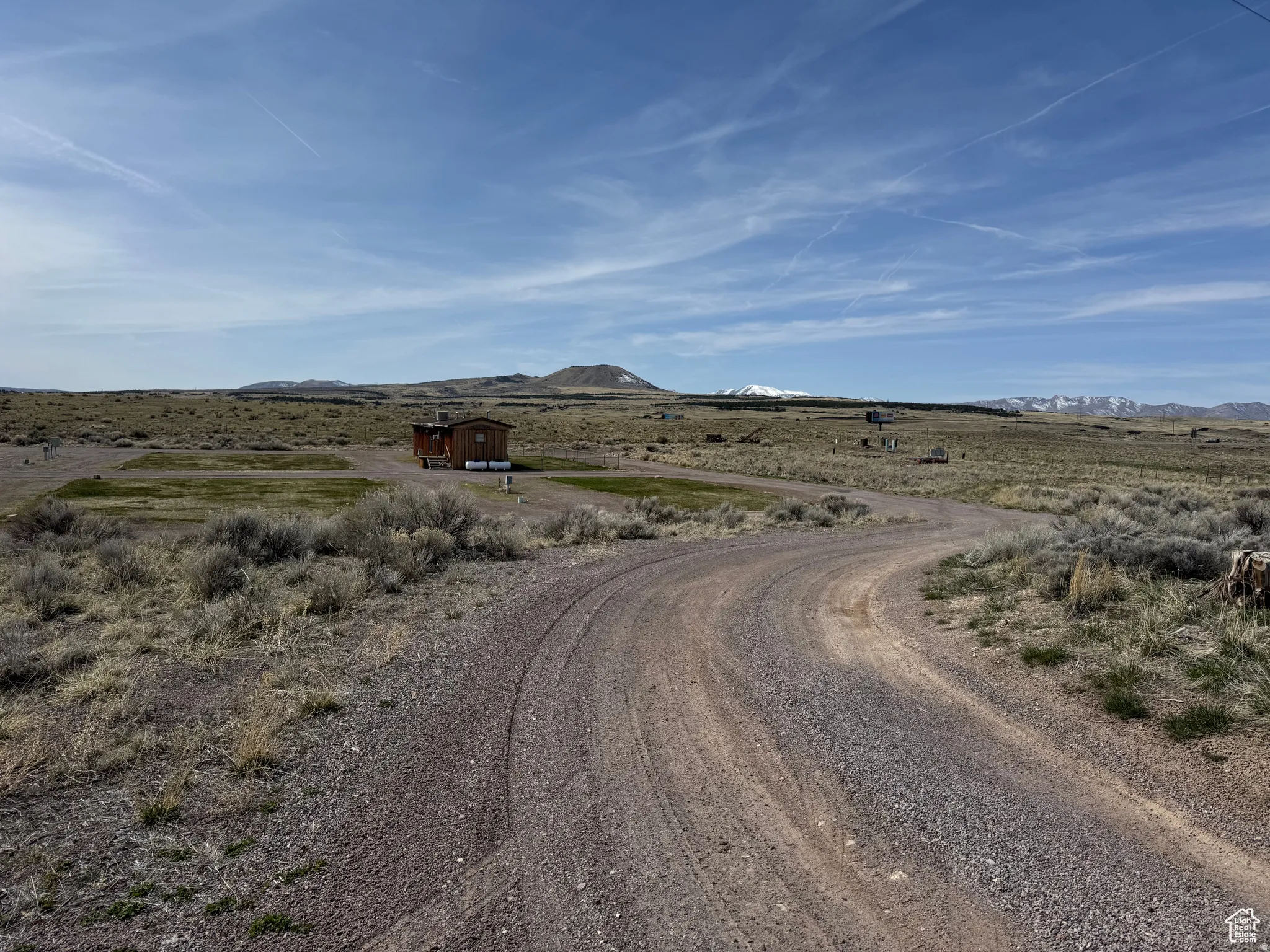 View of dirt / gravel road featuring a mountain view and a view of rural / pastoral area