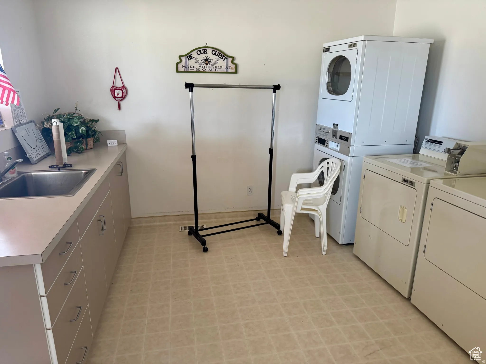 Laundry room featuring light flooring and stacked washer and clothes dryer