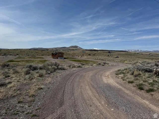 View of dirt / gravel road featuring a mountain view and a view of rural / pastoral area