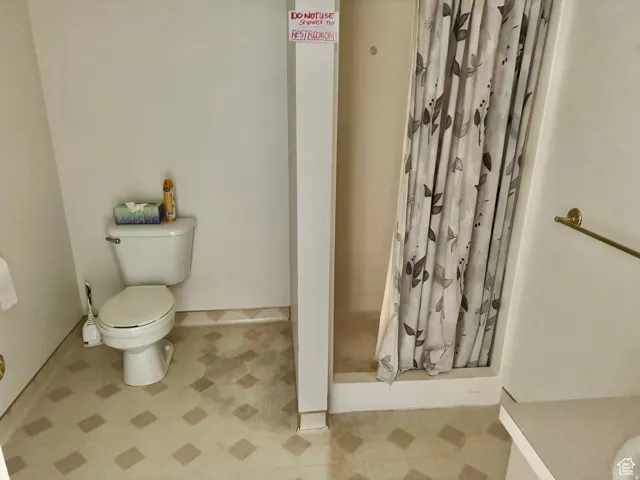 Bathroom with a shower stall and toilet