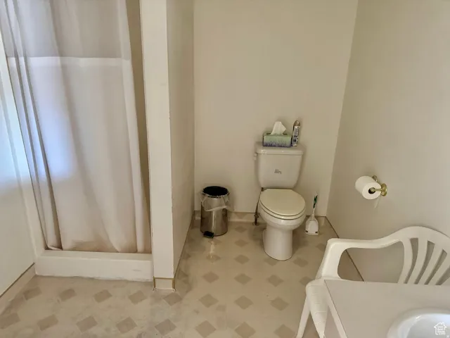 Full bath featuring a stall shower and toilet