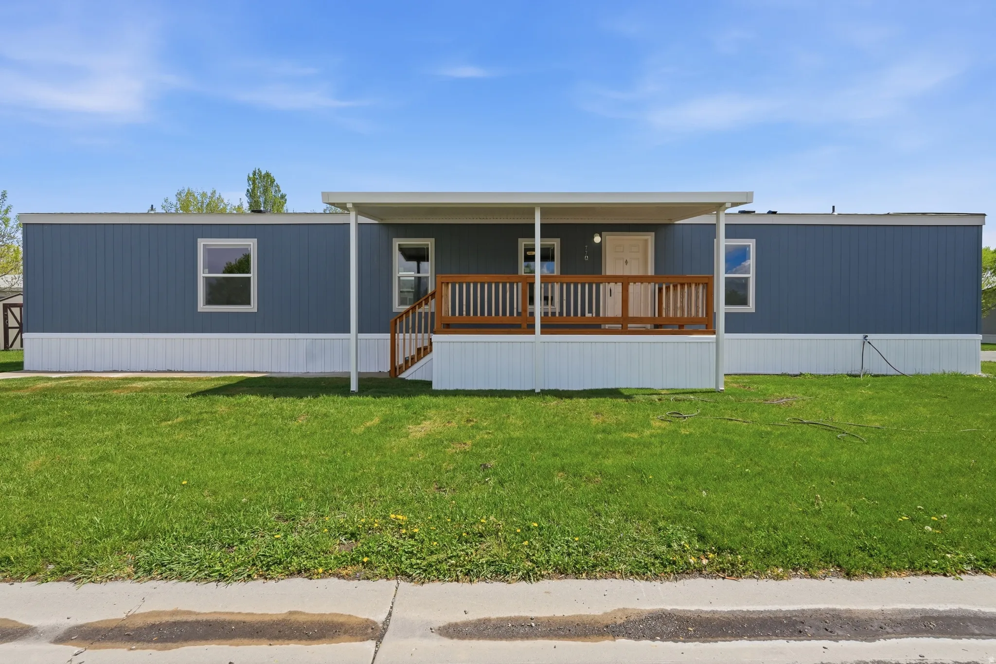 Manufactured / mobile home with a porch and a front lawn