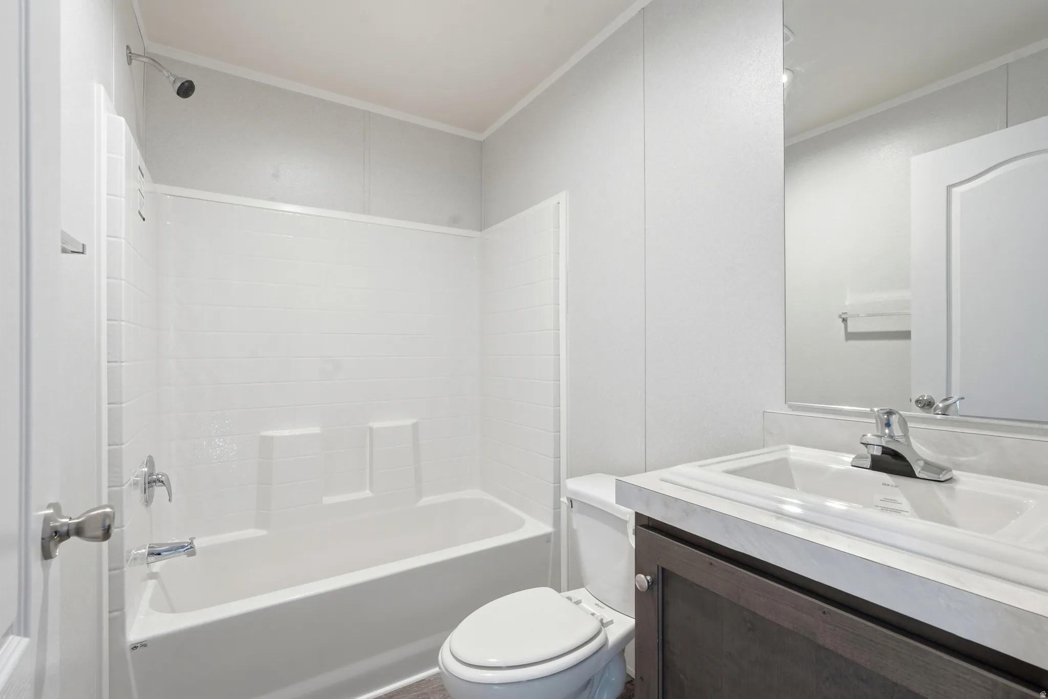 Full bathroom with crown molding, vanity, and washtub / shower combination