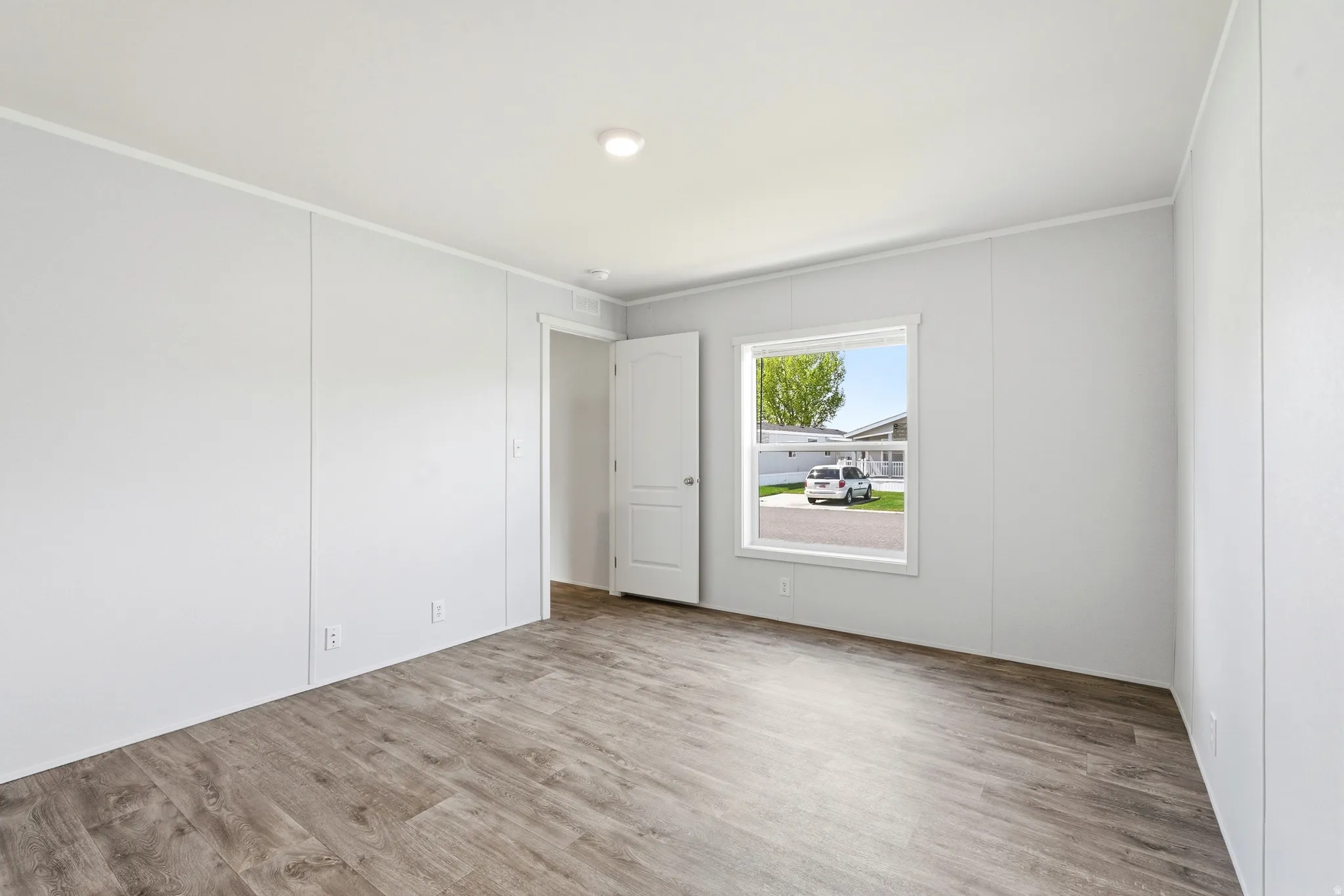 Spare room with light wood finished floors and ornamental molding
