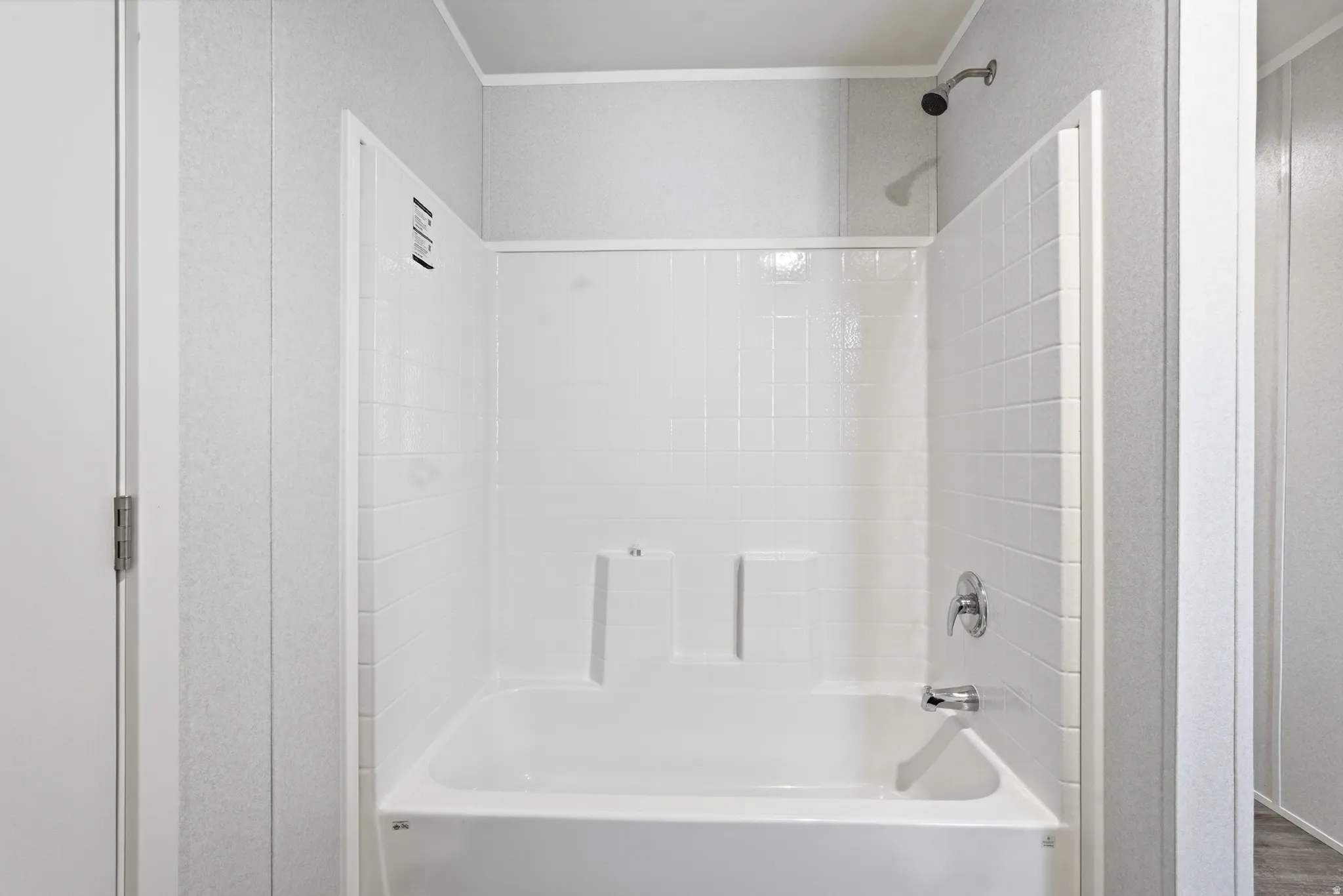 Bathroom featuring tub / shower combination and crown molding