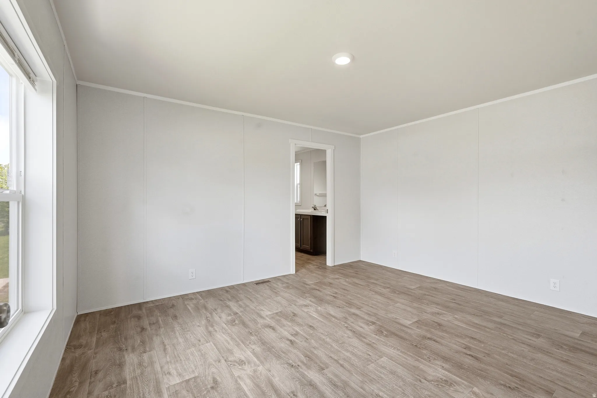 Spare room with light wood-type flooring and crown molding
