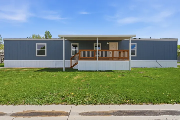 Manufactured / mobile home with a porch and a front lawn